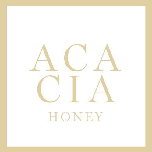 Logo design featuring the words "ACACIA HONEY" in a delicate gold font against a white background, framed by a gold border.