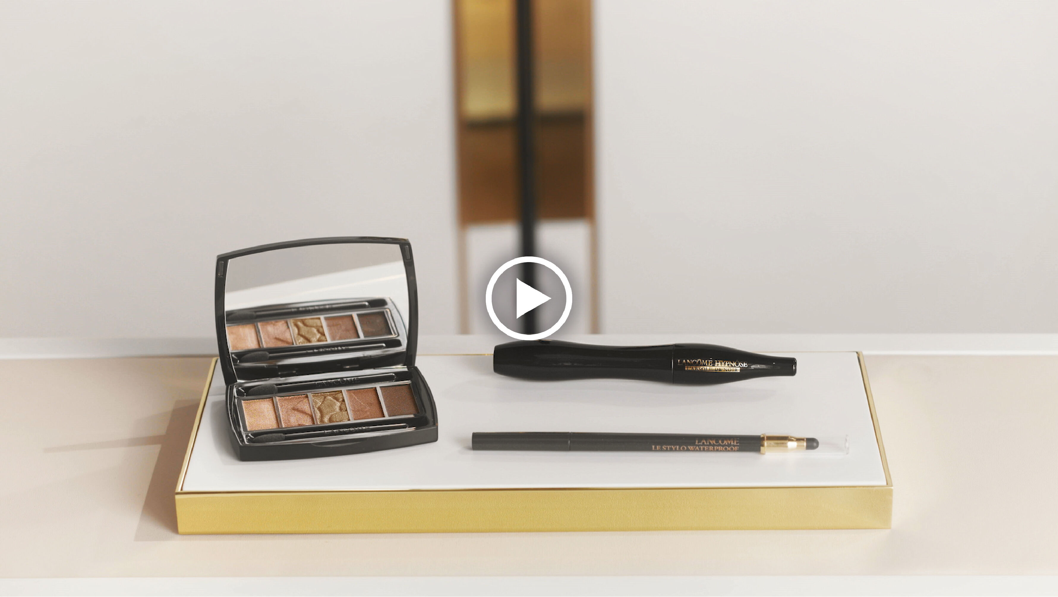 Een luxe make-upset met een spiegeldoosje, oogschaduw, eyeliner en een potlood op een stijlvolle achtergrond.