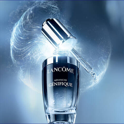 Een flacon van Lancome Advanced Genifique serum met een sprankelend blauwe achtergrond.