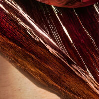 Gros plan sur des strates de tissus aux couleurs riches, evoquant la texture et la profondeur.