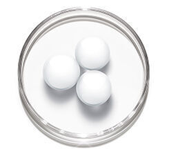 Three white spheres are arranged in a circular petri dish on a white background.