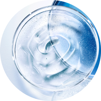 Transparent gel in een ronde glazen kom met luchtbelletjes, tegen een achtergrond van blauw en wit.