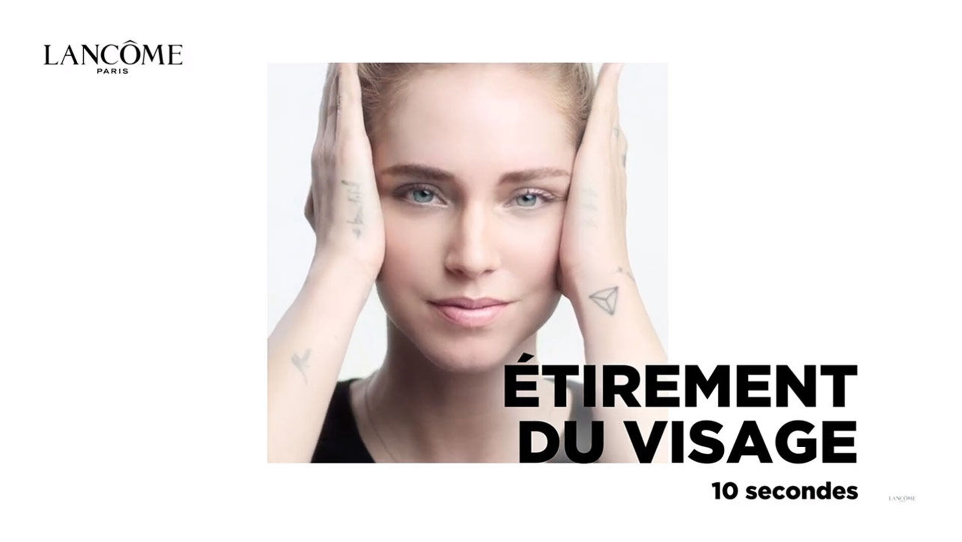 Une femme souriante realise un exercice d’etirement du visage, mains sur les joues, dans un cadre lumineux et epure.