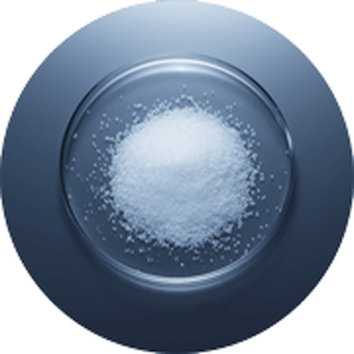 Een ronde schaal met een witte, kristallijne stof, waarschijnlijk zout, op een donkere achtergrond.