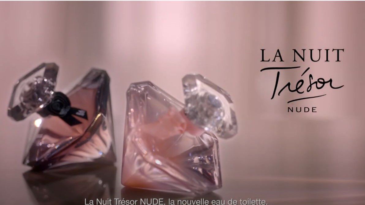 Deux flacons de parfum en forme de diamant, etiquetes 'La Nuit Tresor NUDE', avec un fond subtil et elegant.