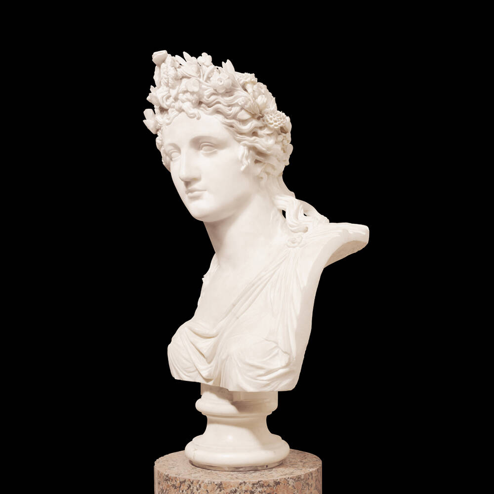 Buste en marbre représentant une figure masculine ornée de fleurs, sur socle, sur fond noir.